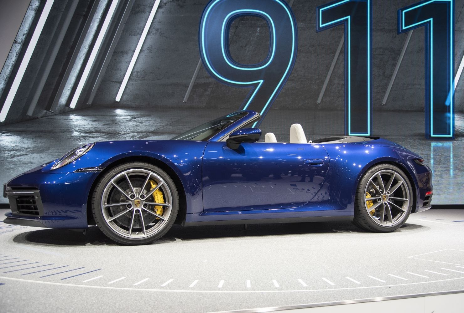 Blue convertible sports car with yellow brake calipers and alloy wheels