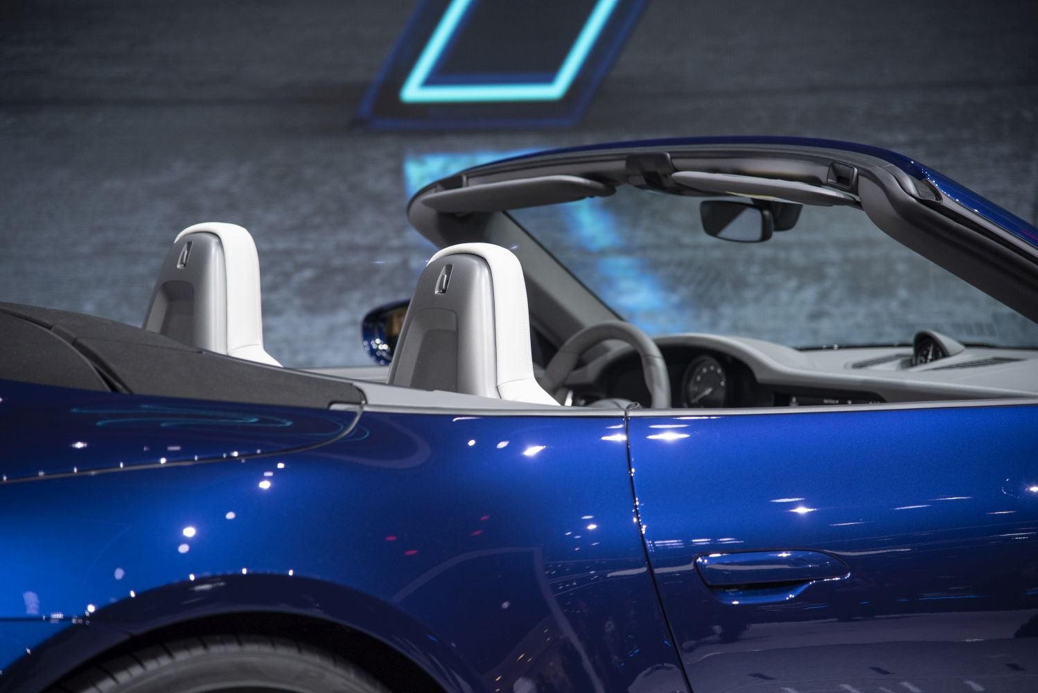 Convertible sports car with white headrests and blue side body