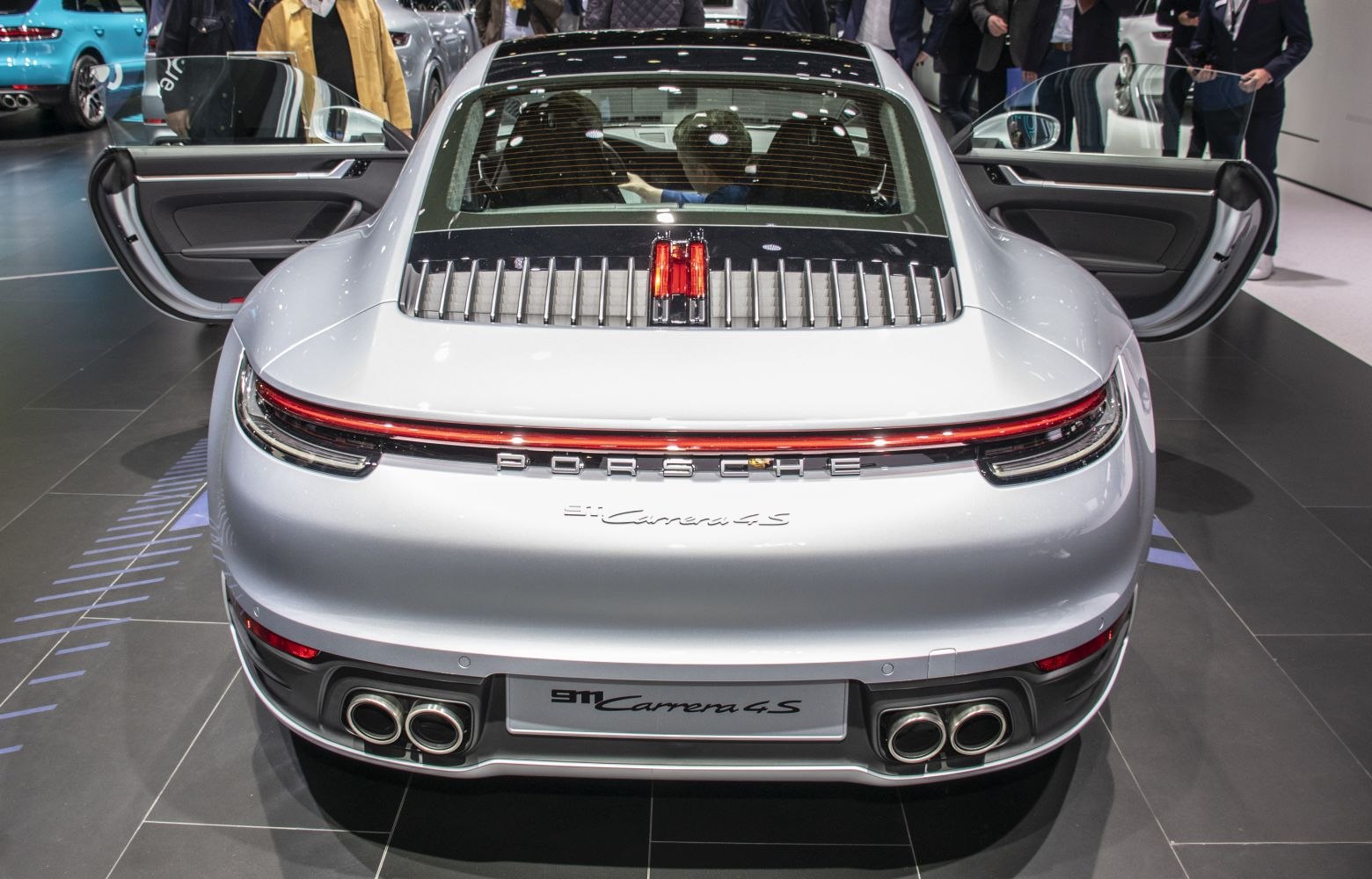 Rear view with distinct taillight strip, quad exhaust tips, open doors