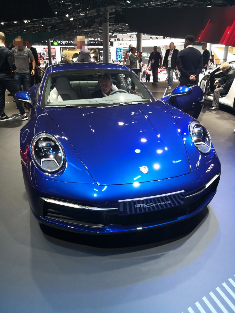 Front view of blue sports coupe with round headlights and contoured hood