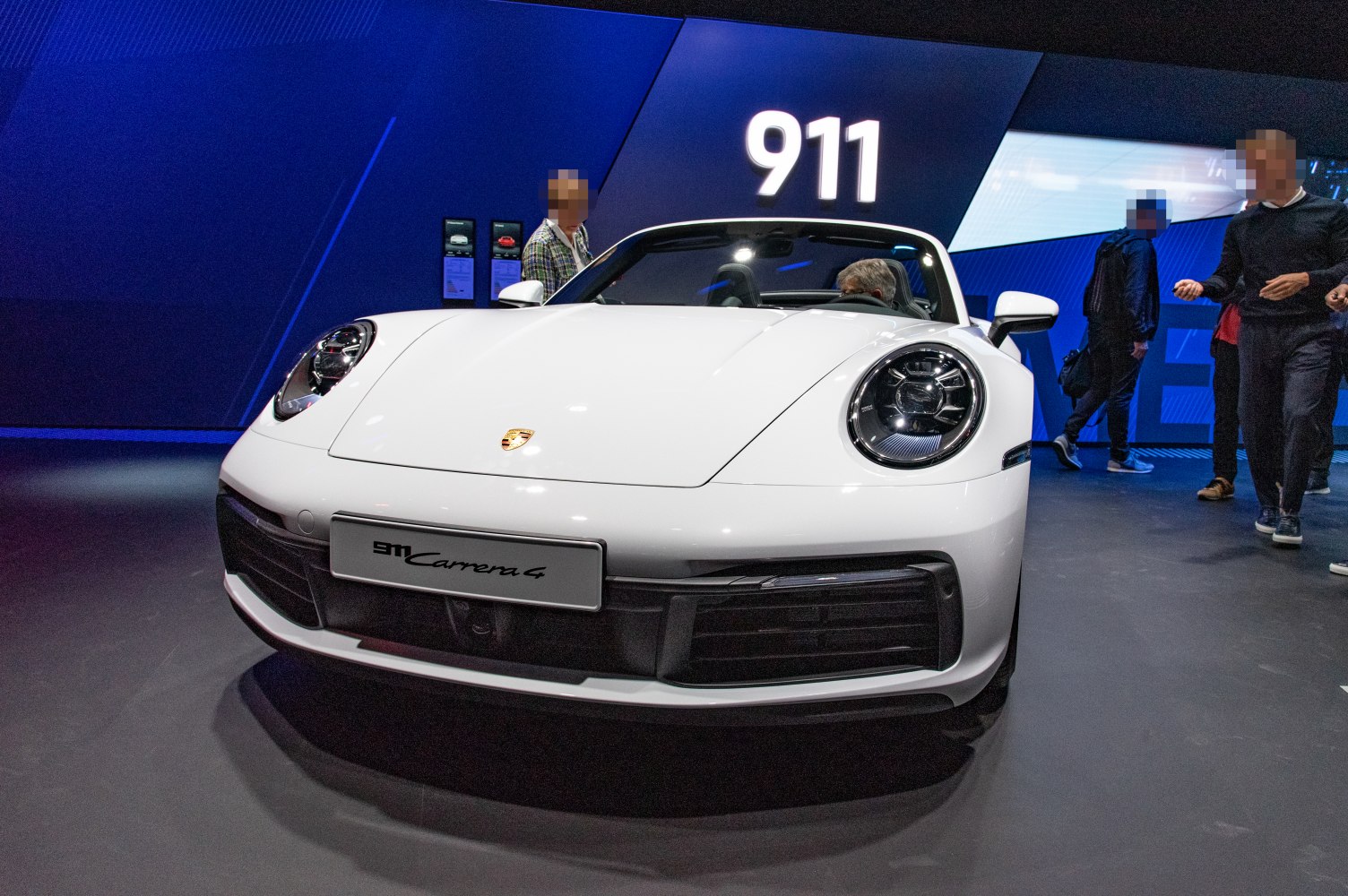 Front view of Porsche 911 with prominent headlights and convertible roof