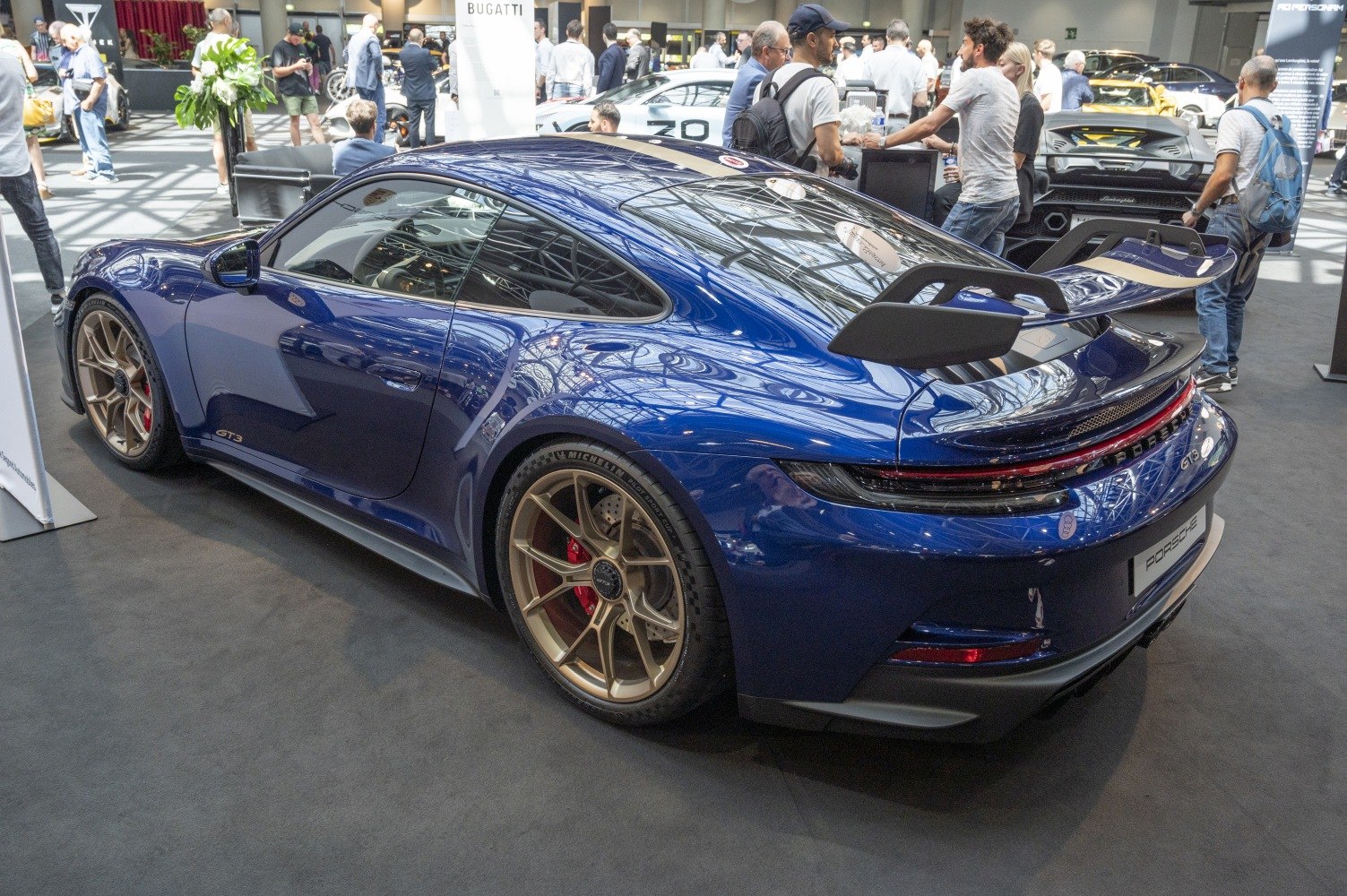Large rear spoiler and gold alloy wheels on blue sports coupe