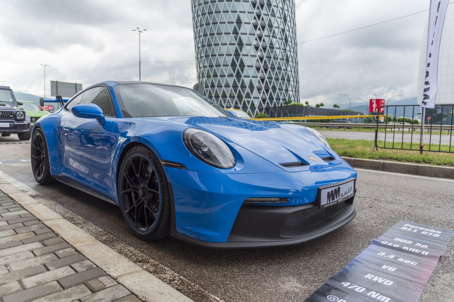 Blue sports coupe with aerodynamic front and black performance wheels.