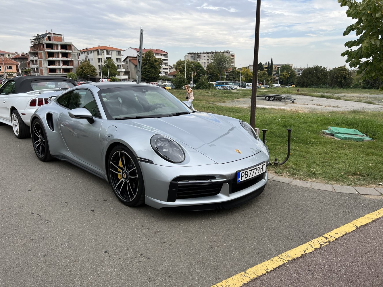 Silver Porsche 911 992 Turbo front-side view with black wheels