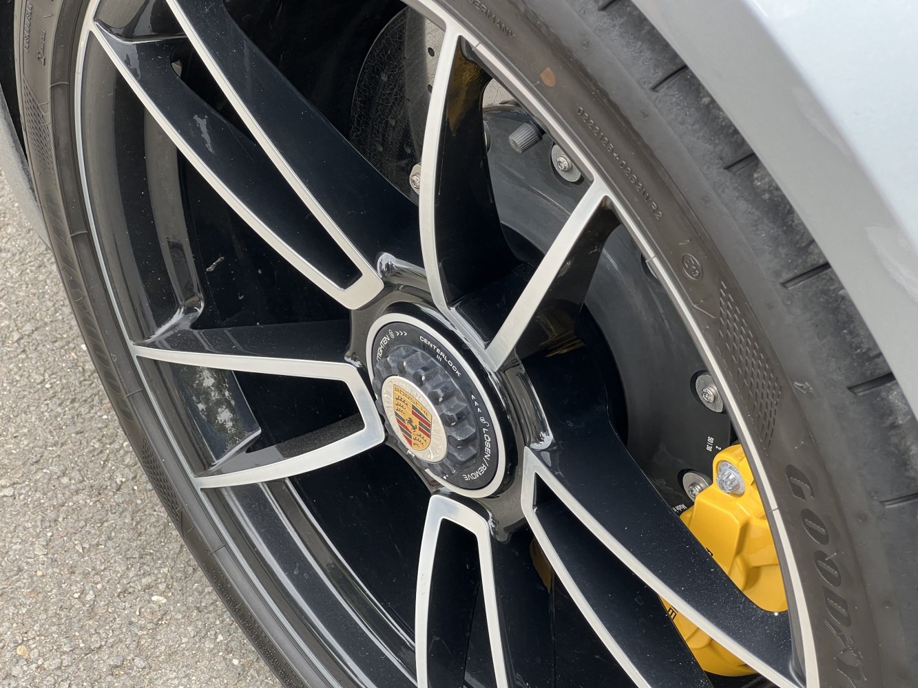 Black alloy wheel with yellow brake caliper and centerlock hub