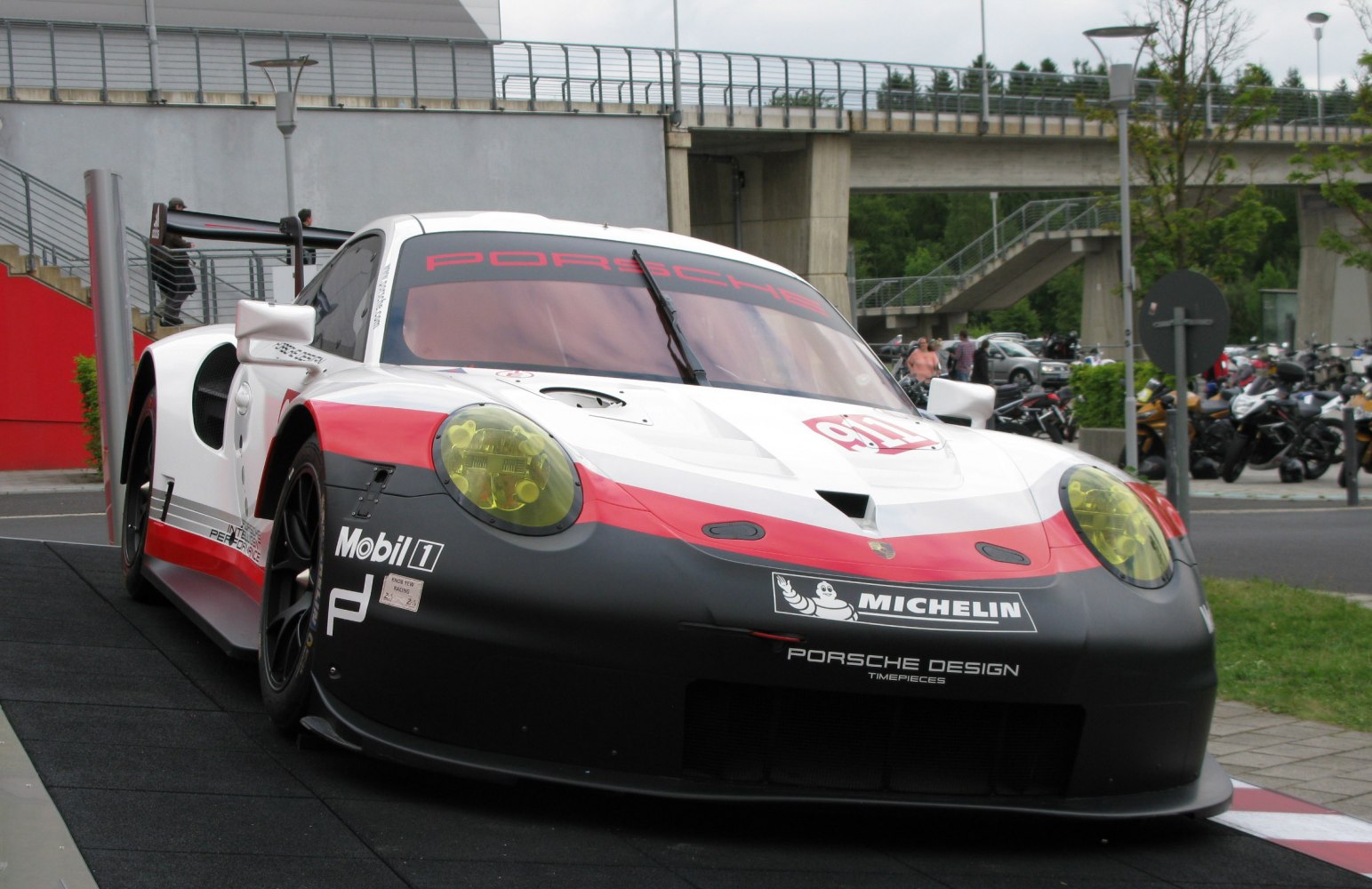 Aerodynamic race car front with yellow headlights and sponsor decals