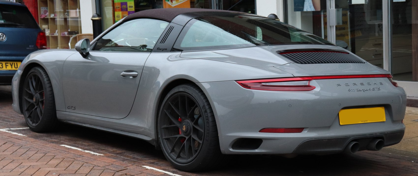 Rear view with soft top roof and black alloy wheels