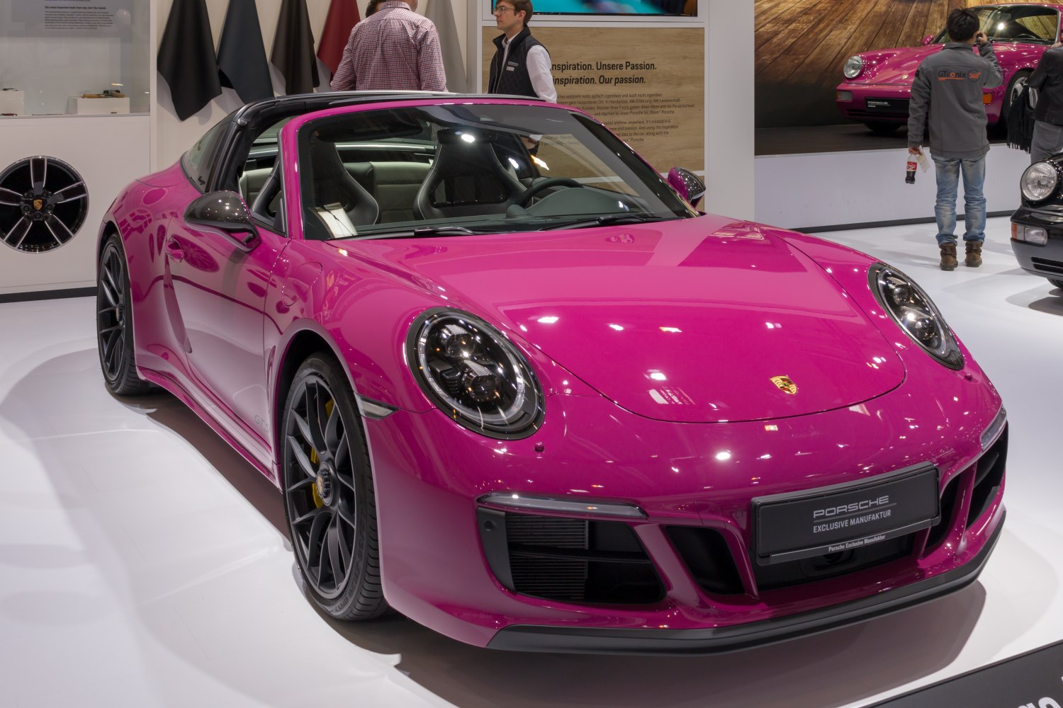 Pink Porsche 911 Targa with carbon mirrors and black wheels at an auto show