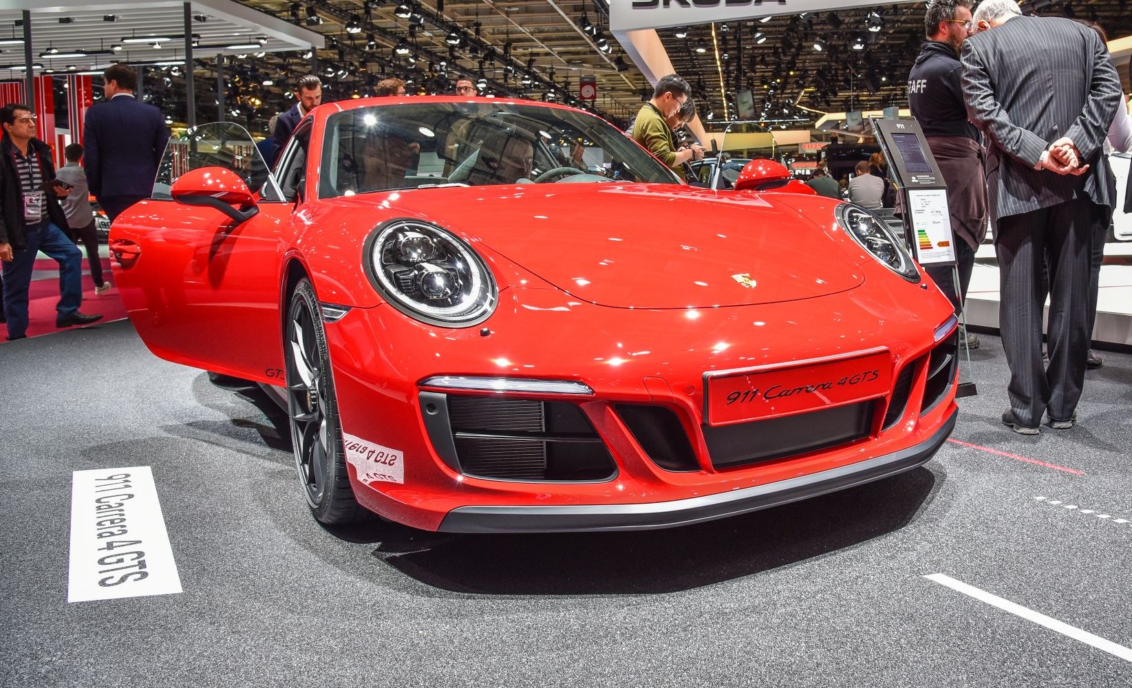 Front view of red sports car with open door and round headlights