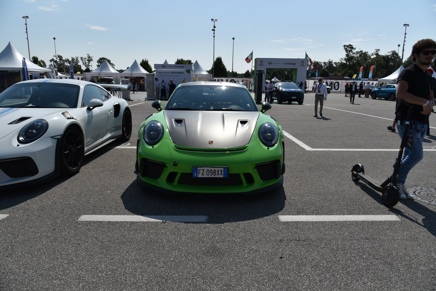 Green sports car with vented carbon hood and round headlights