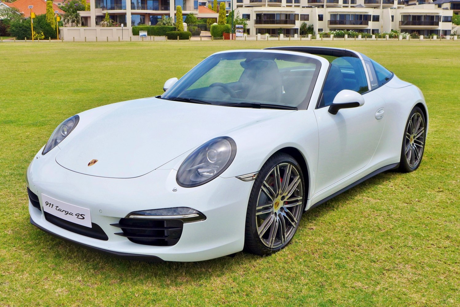 White sports car with Targa open roof and multi-spoke wheels
