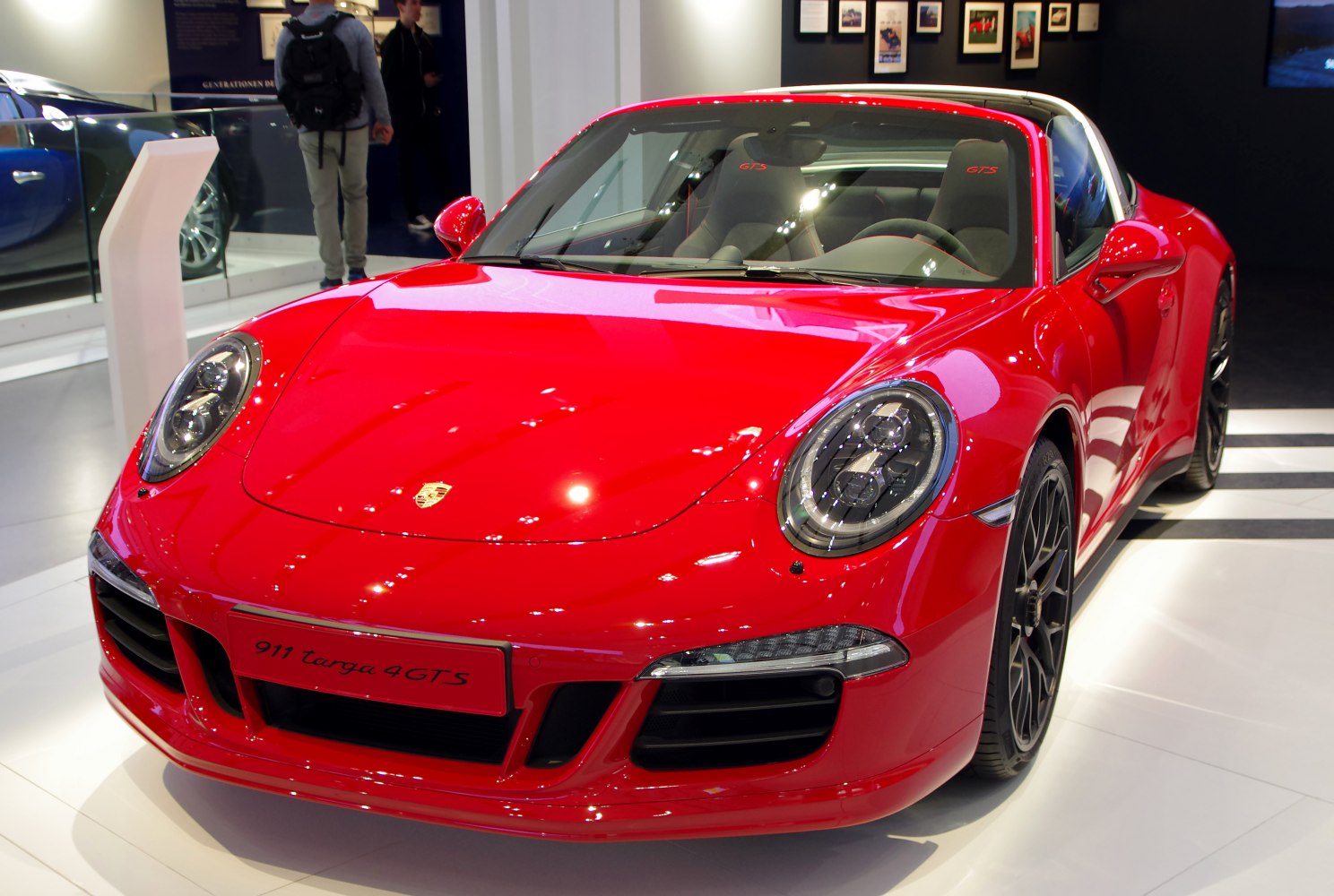 Red front view of sports coupe with prominent round headlights and sporty front bumper