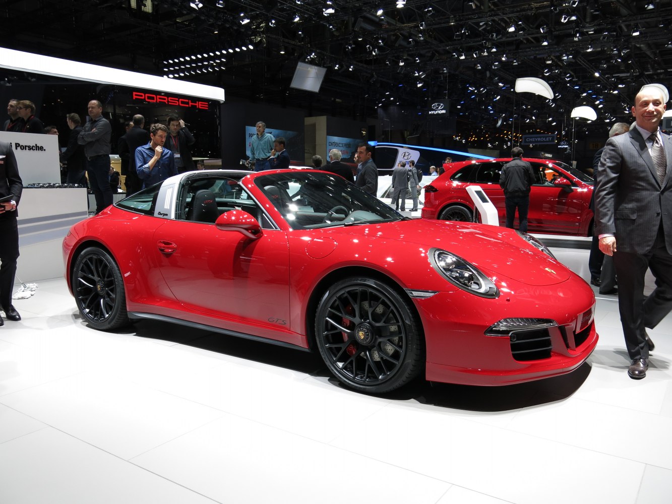 Red sports coupe with Targa roof and black multi-spoke wheels.