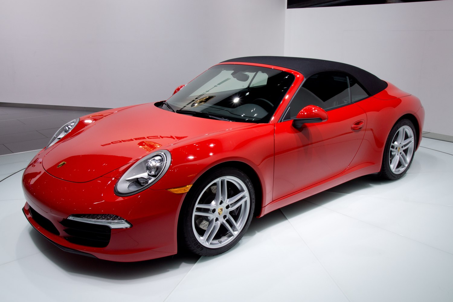 Red convertible sports car with black soft top and silver alloy wheels