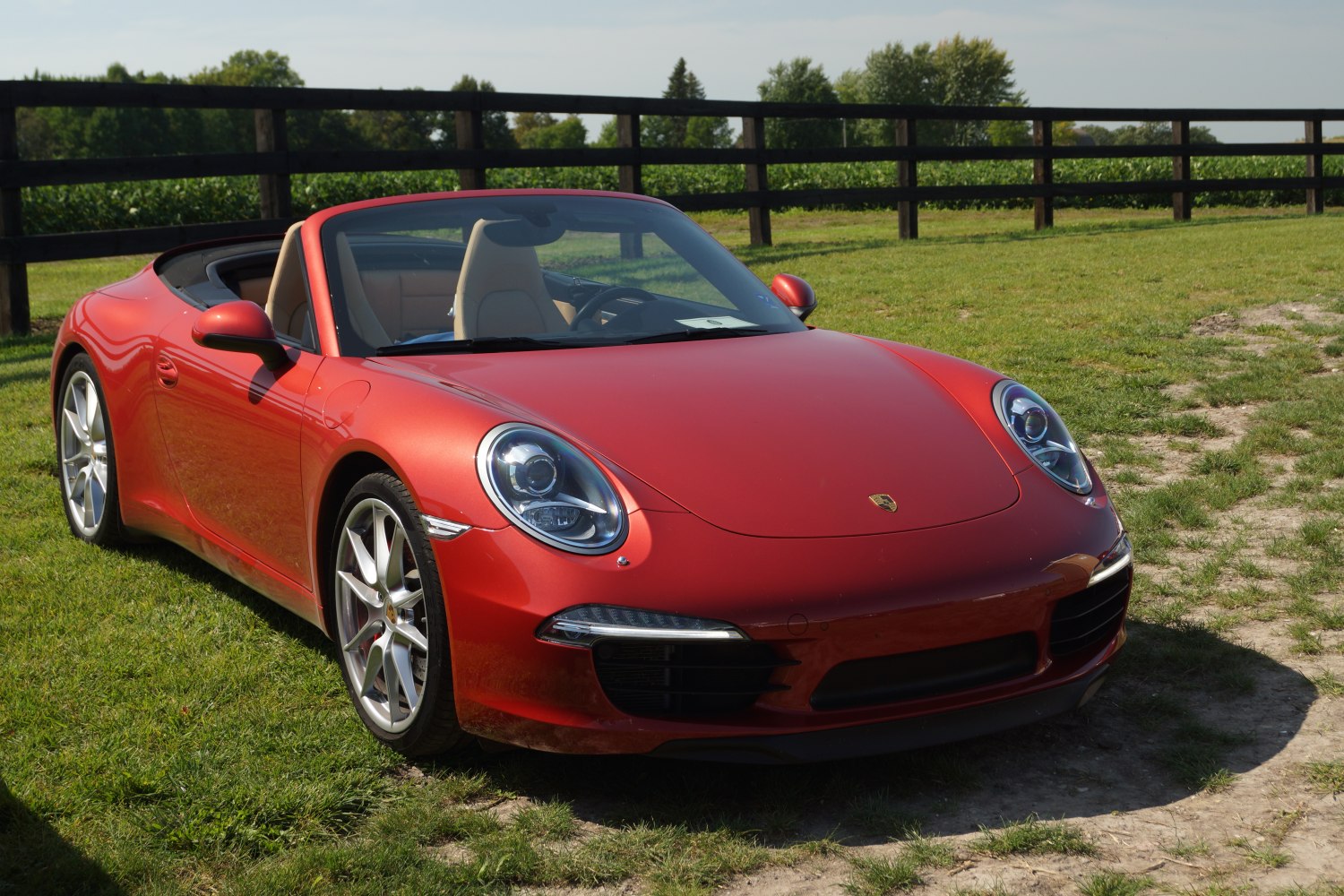 Red convertible sports car with round headlights and alloy wheels