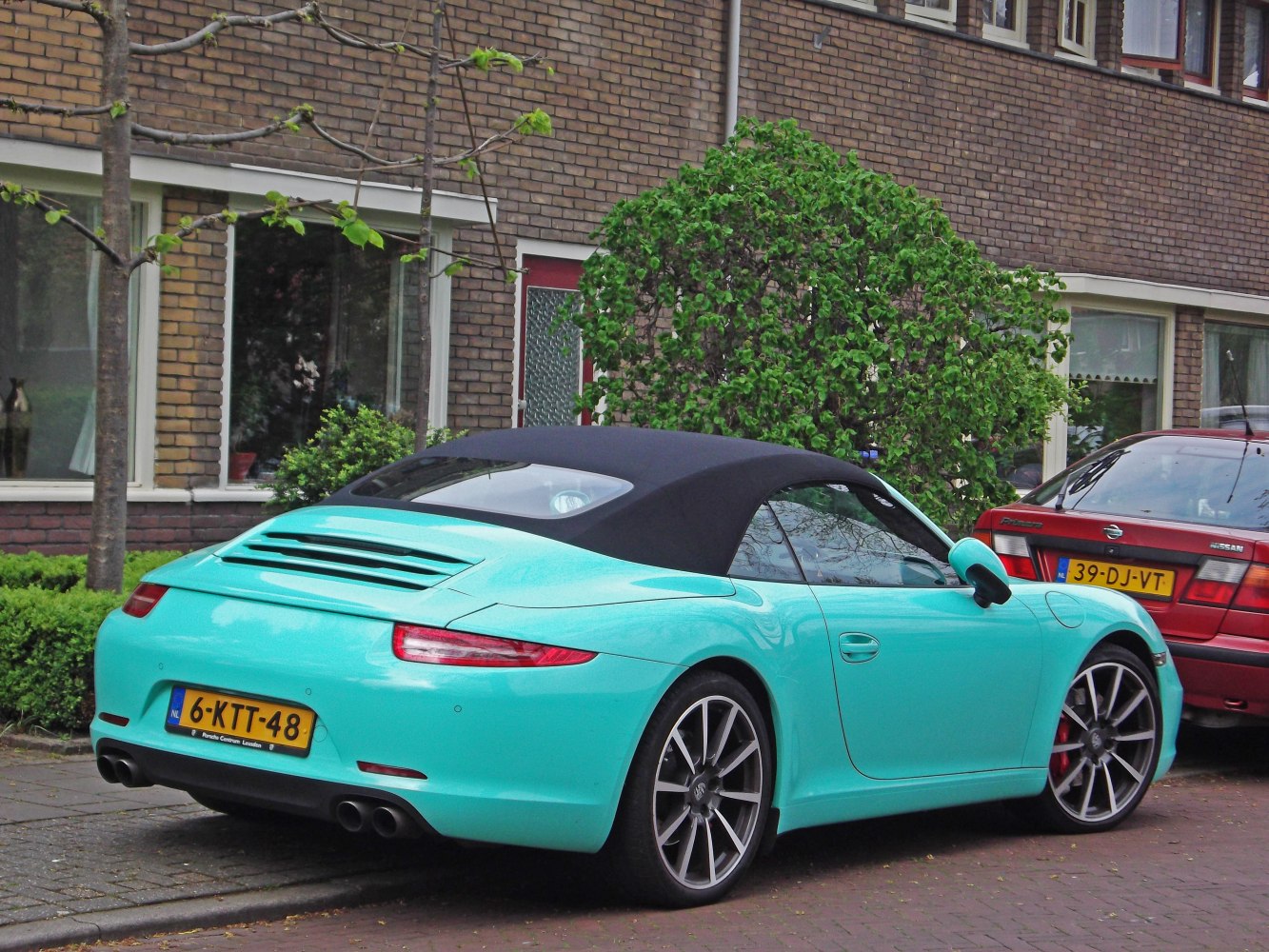 Rear three-quarter view of convertible with black soft top and quad exhaust