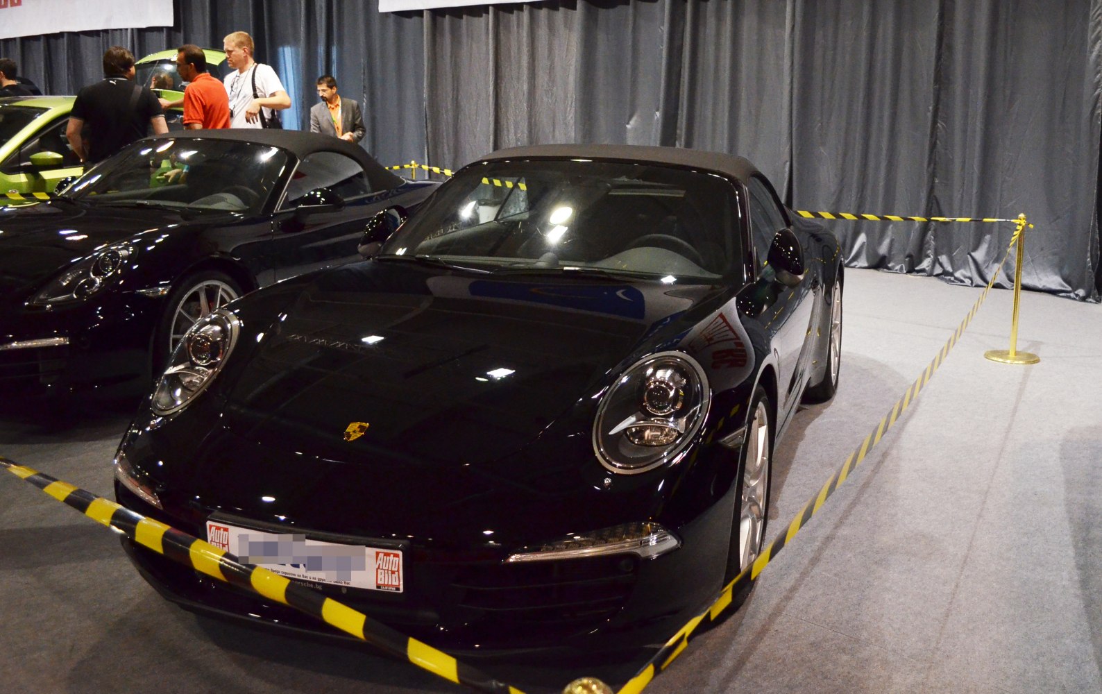 Front view of convertible with closed soft top and iconic rounded headlights.