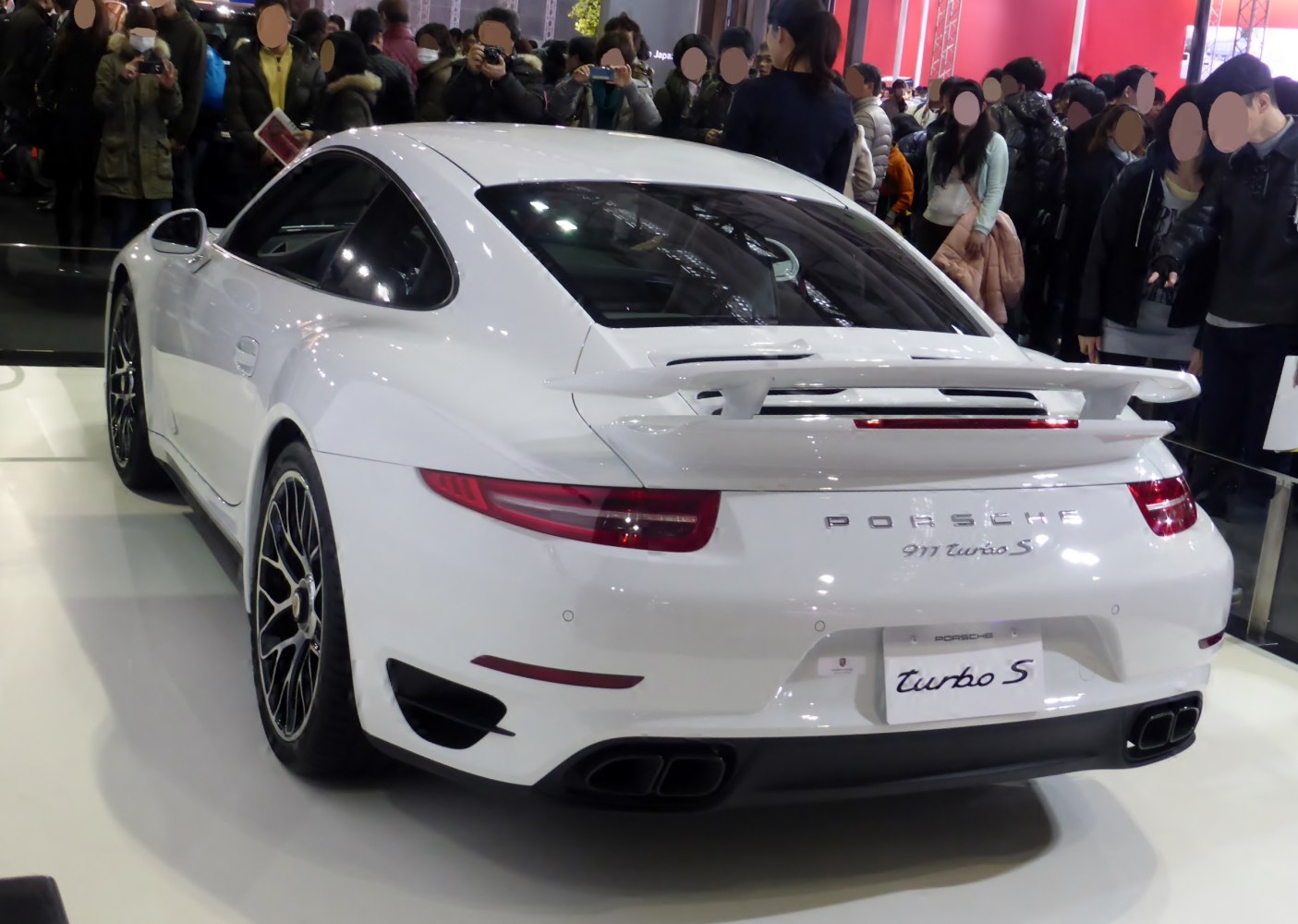 Rear view of white sports car with rear spoiler and quad exhaust