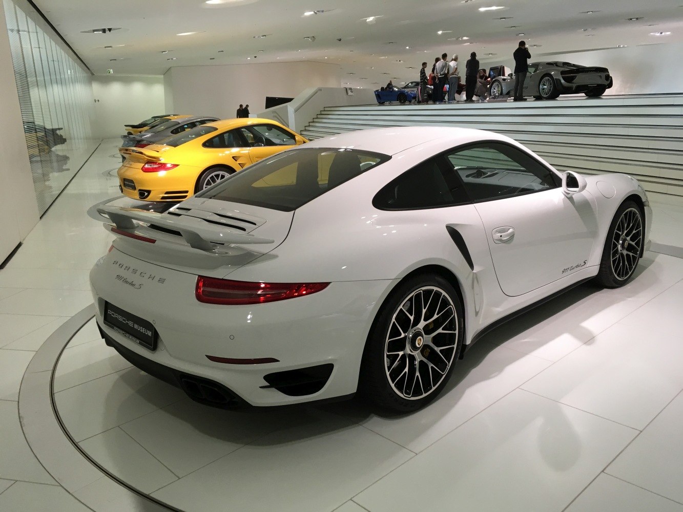 Rear and side profile of a sports coupe with rear spoiler and multi-spoke wheels