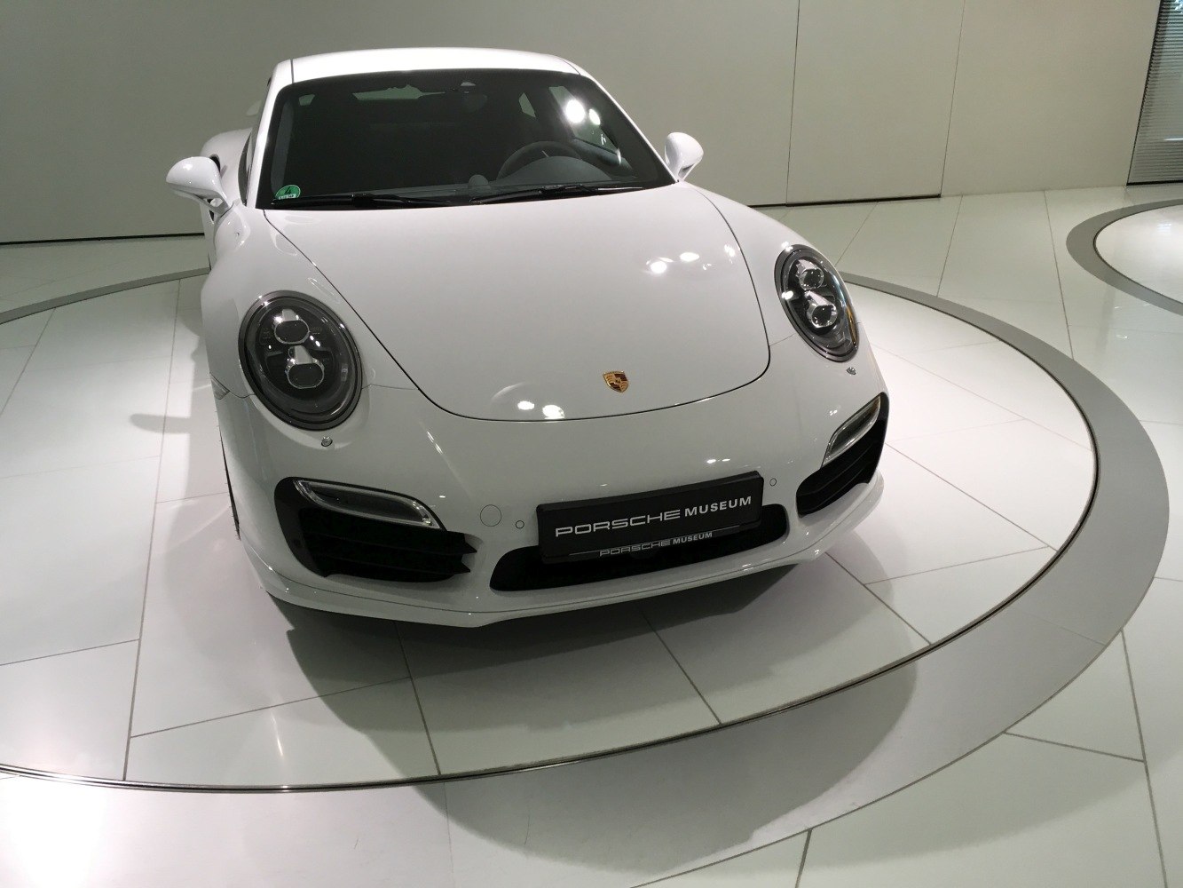 White sports coupe front with round headlights and sleek hood