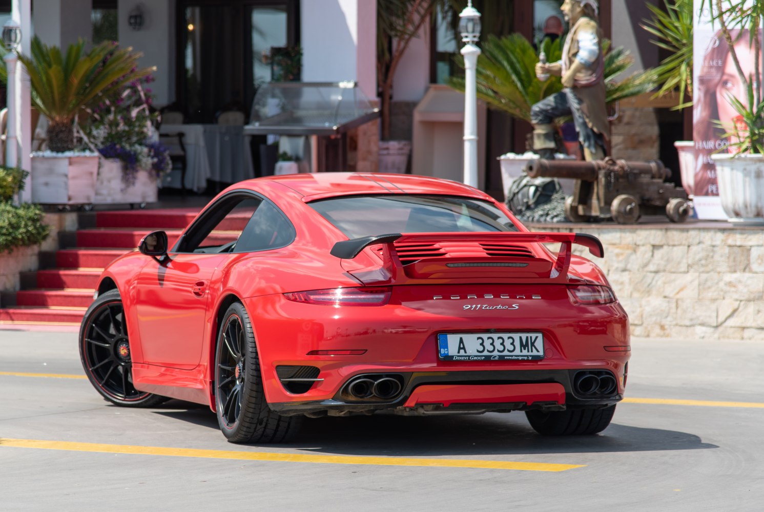Rear view of sports car with large rear wing and quad exhaust tips