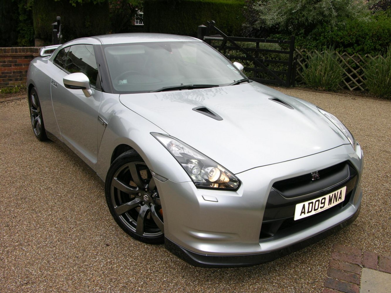 Silver sports coupe with vented hood and black alloy wheels