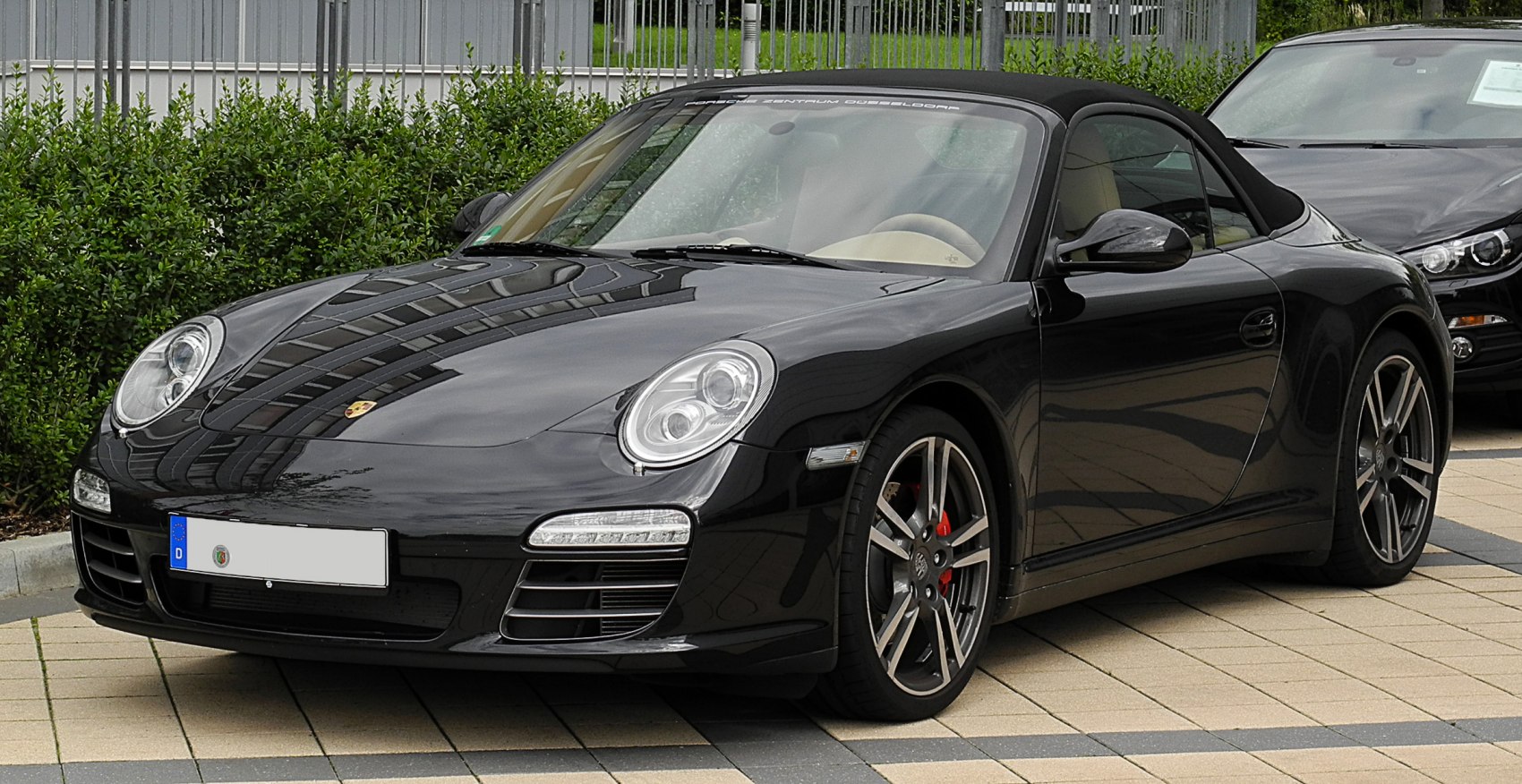 Convertible sports car with black soft top and alloy wheels