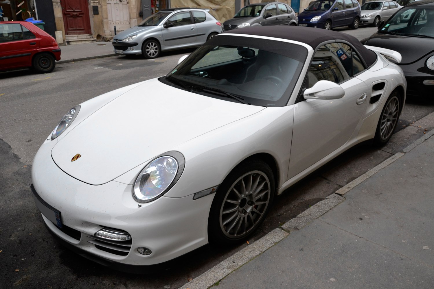 White sports convertible with soft top and round headlights
