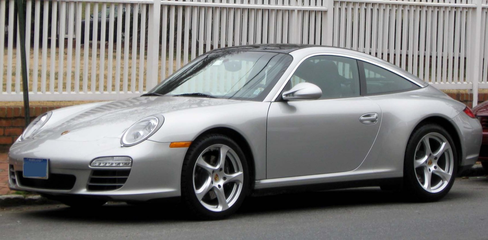 Silver sports car with rounded headlights and five-spoke alloy wheels