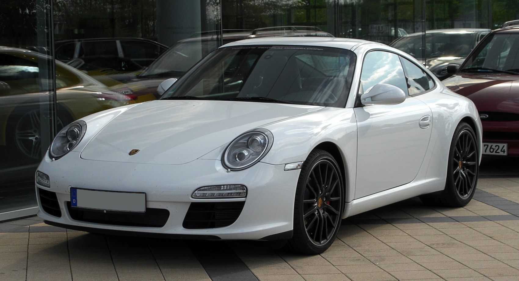 White coupe with round headlights and black alloy wheels