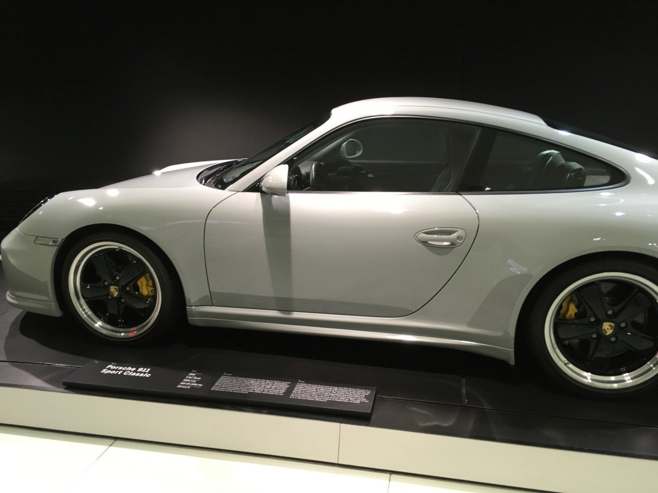 Silver coupe side profile with black wheels and yellow brake calipers