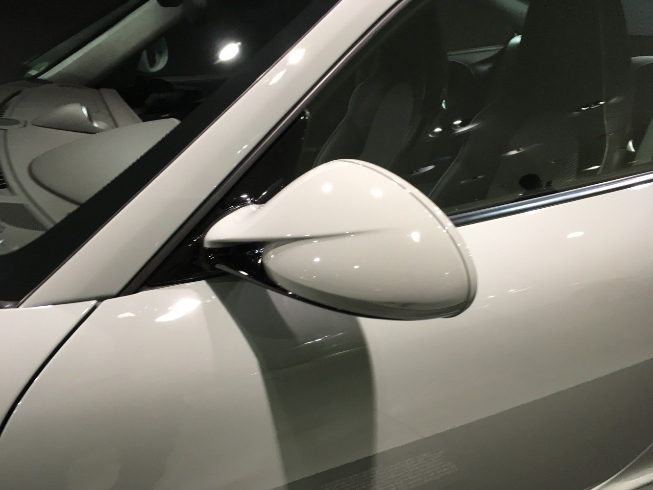 Side mirror and A-pillar with interior visible through window