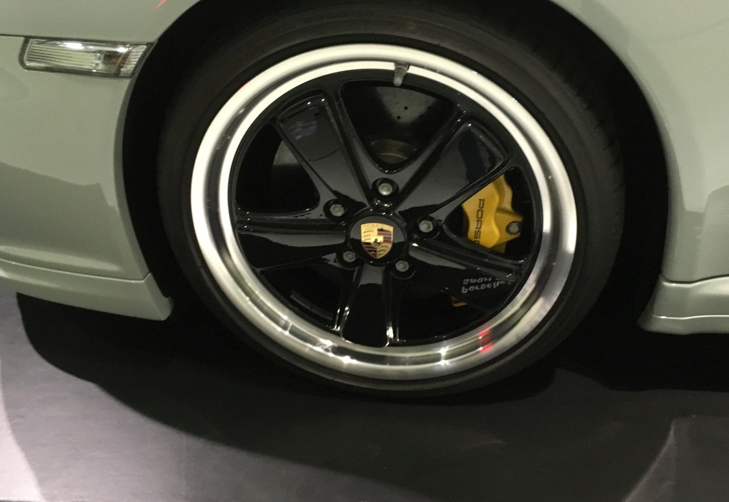 Glossy black alloy wheel with yellow brake caliper