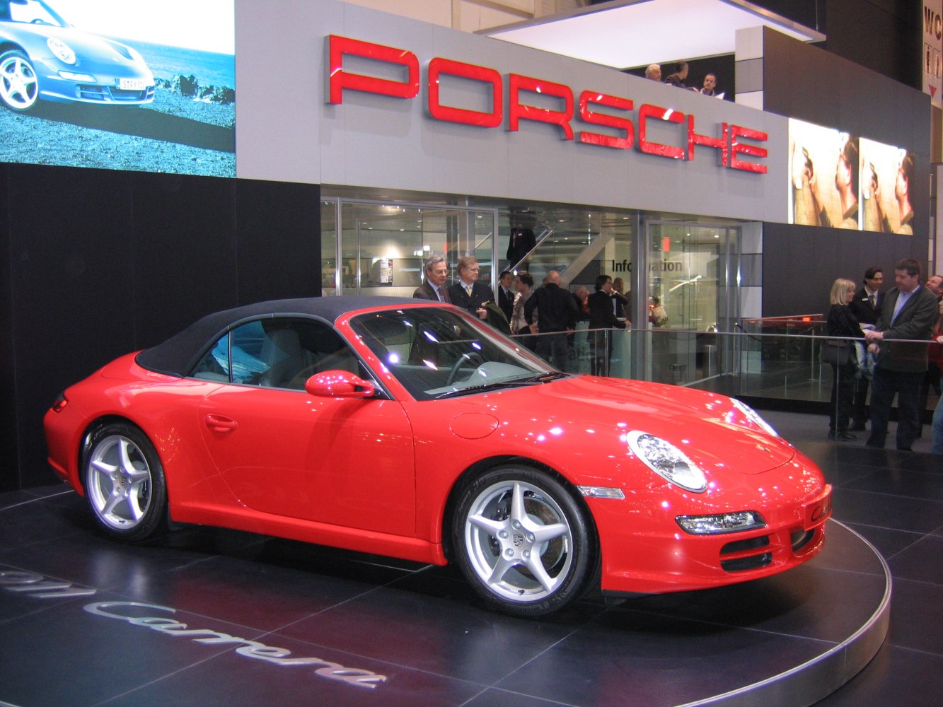 Red convertible with soft top, sleek headlights, five-spoke alloy wheels
