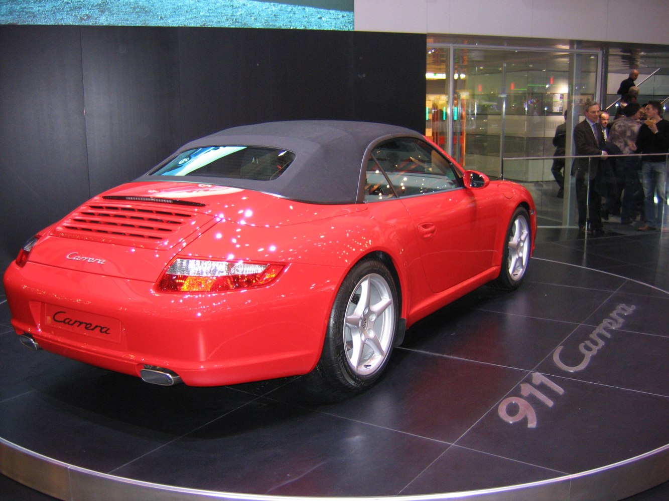 Rear view of a red convertible with closed soft top and alloy wheels