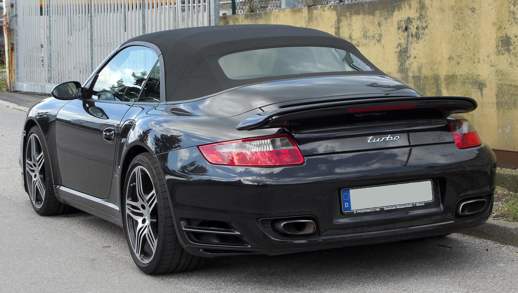 Rear view of a sporty convertible with rear spoiler and dual exhausts
