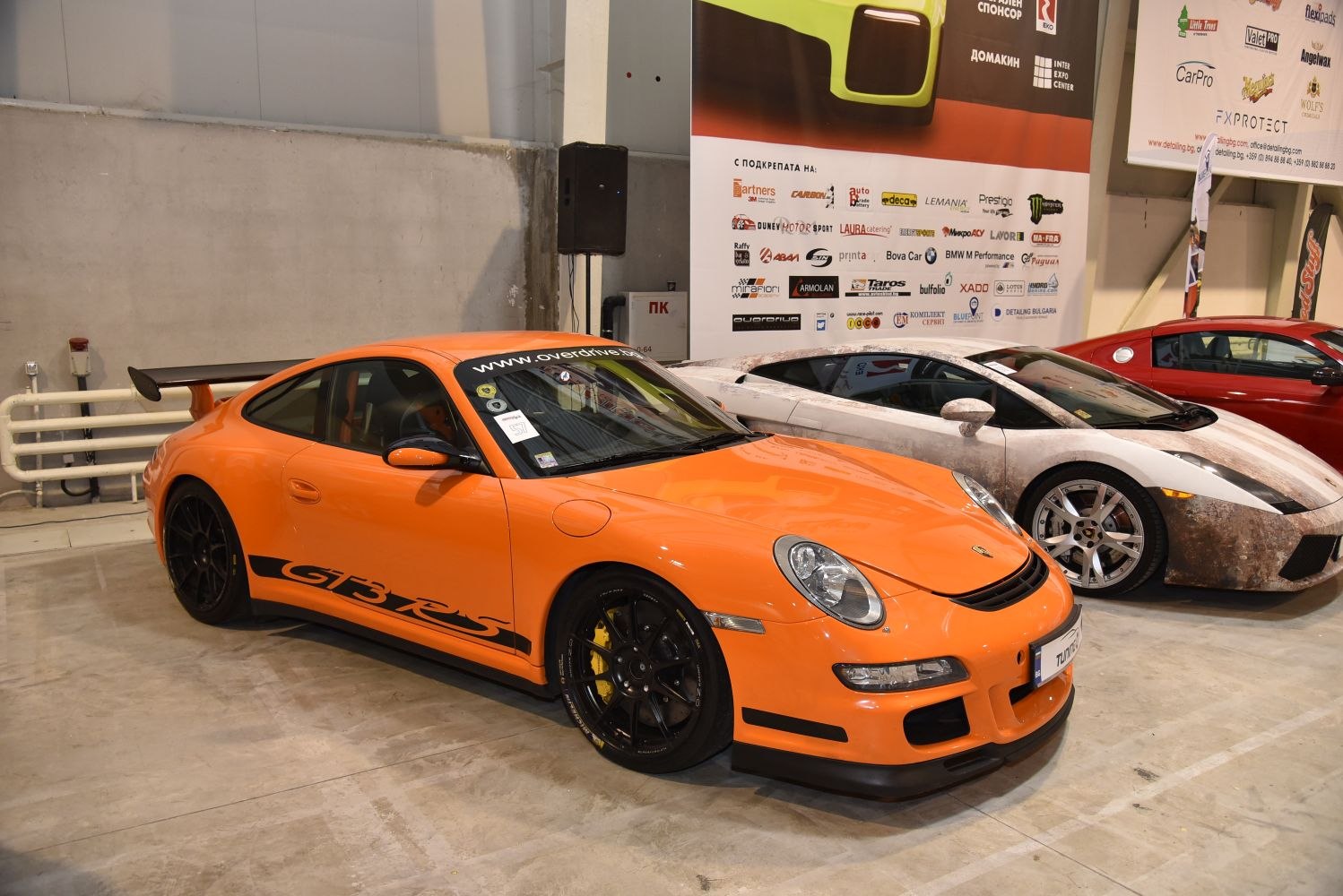 Orange sports coupe with large rear wing and black wheels