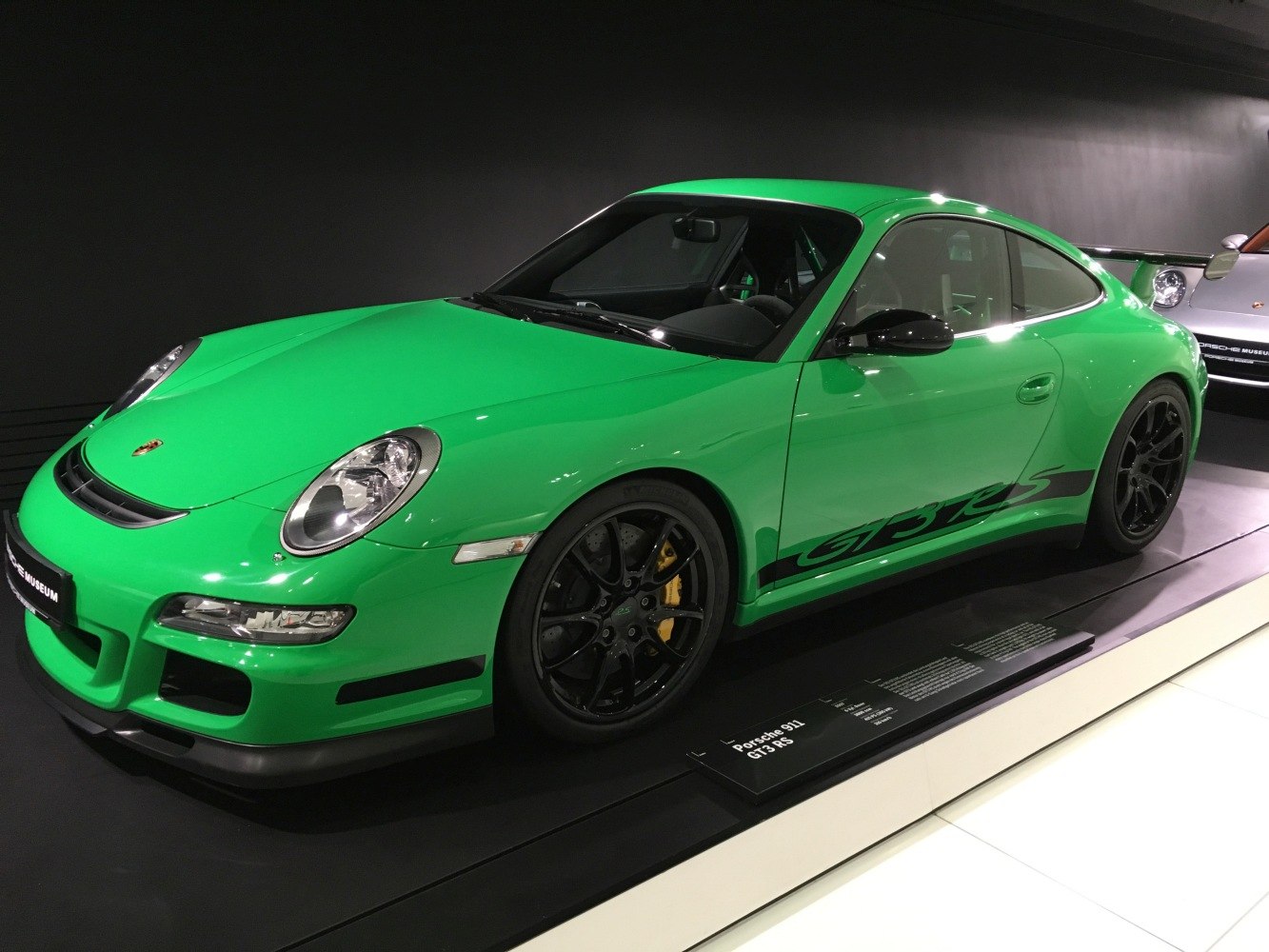 Bright green sports coupe with black alloy wheels and rear wing