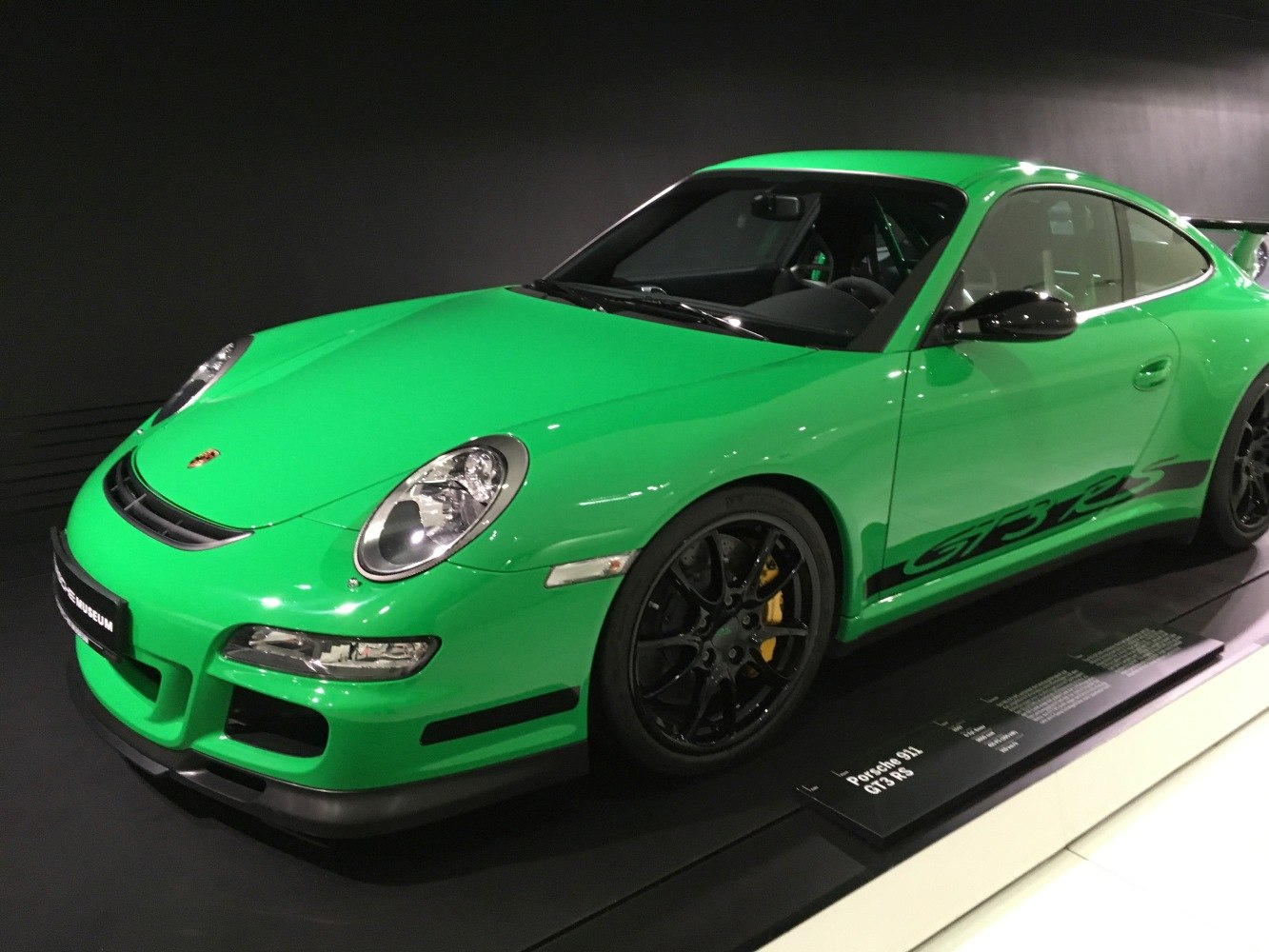 Green sports coupe with black wheels and aerodynamic front styling