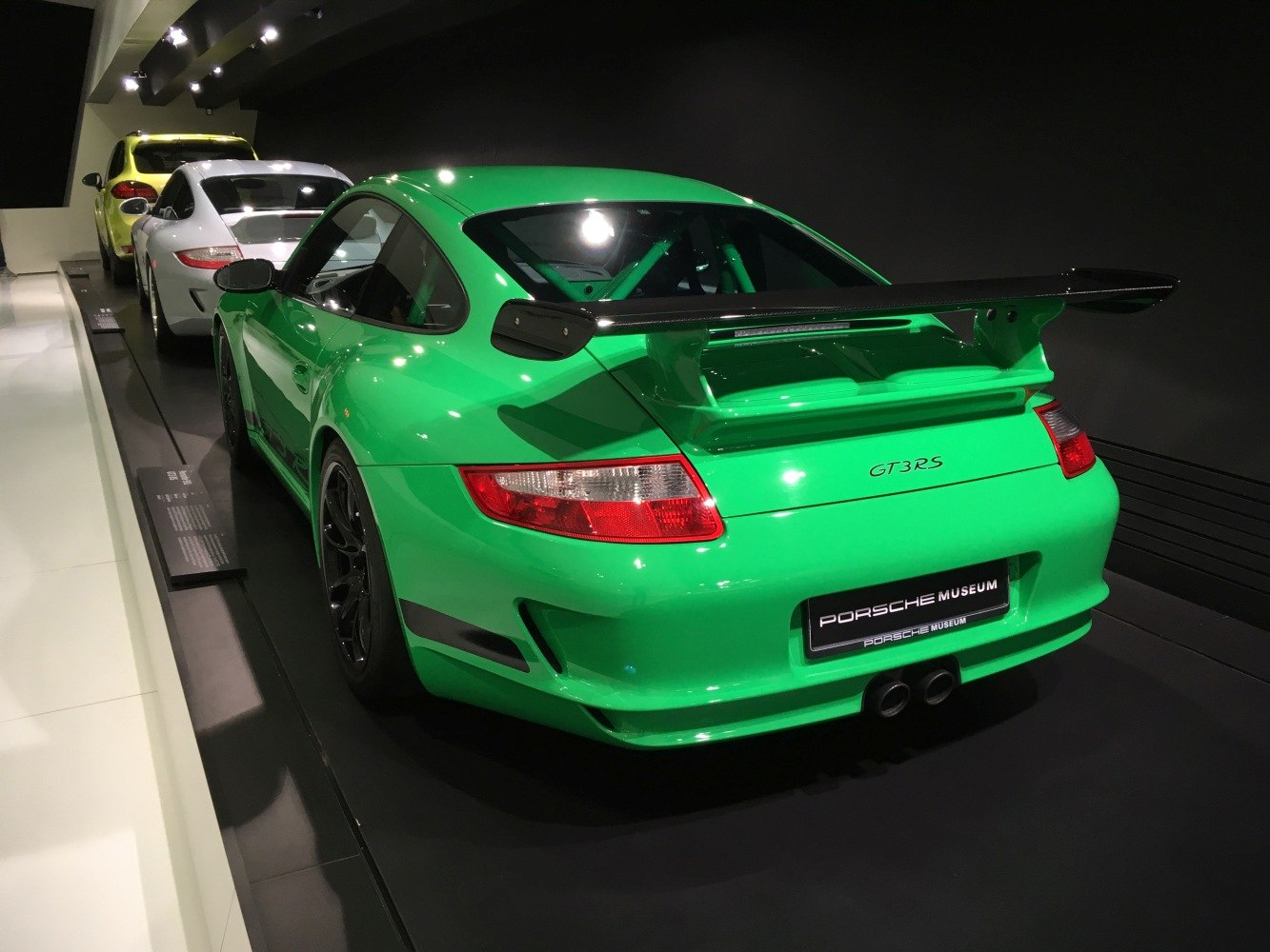 Rear view of a green 911 997 GT3 RS with large rear wing and roll cage