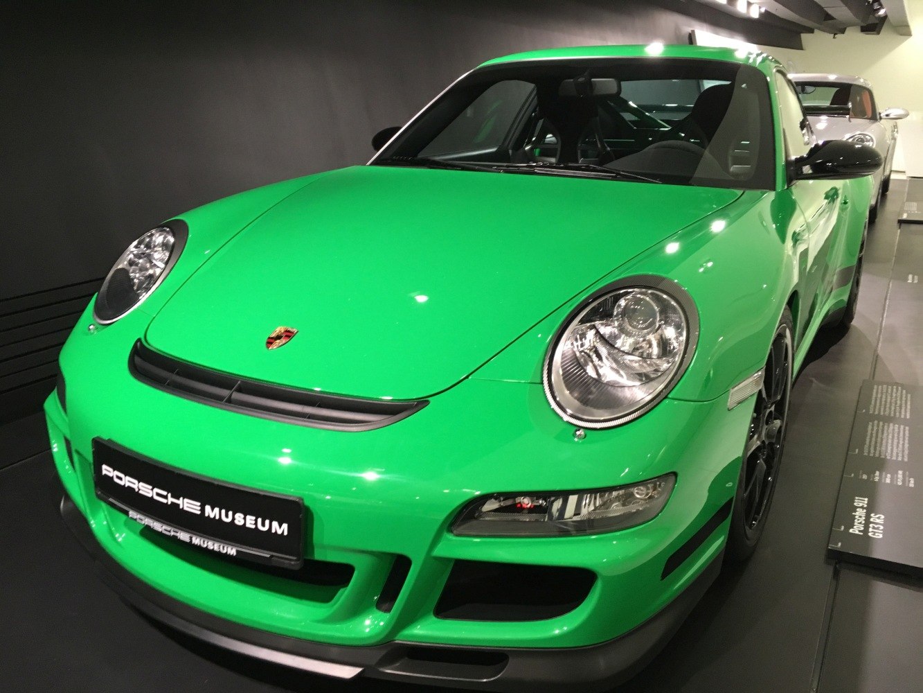 Close-up front of green sports car with round headlights and aerodynamic design