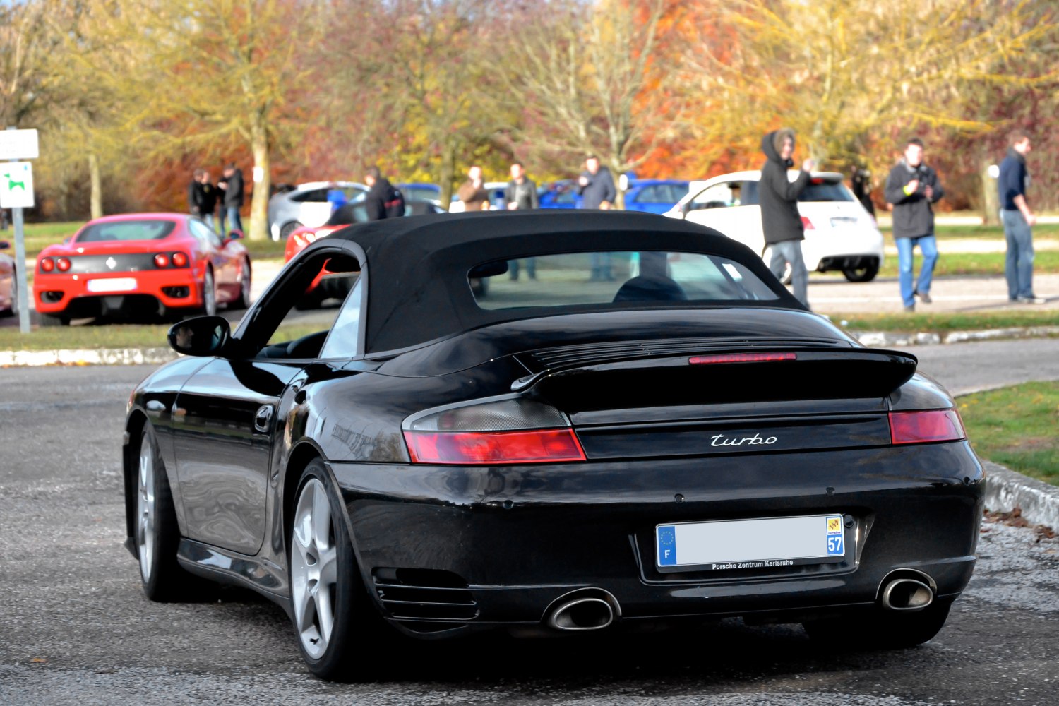Rear view of black cabriolet showing turbo badge, tail lights and soft top