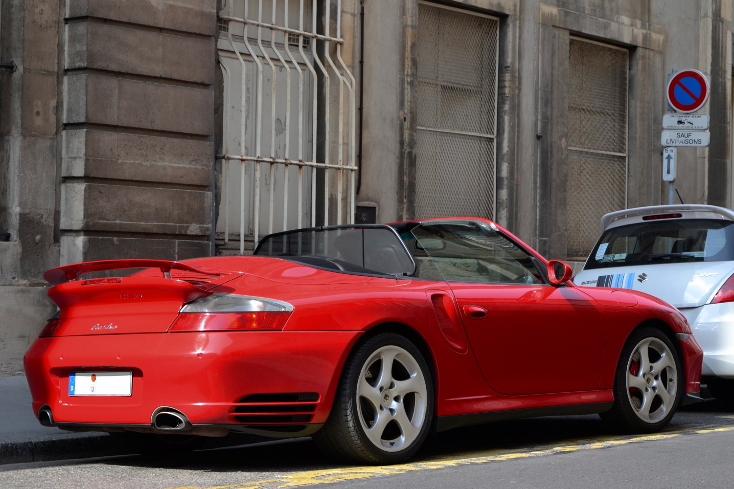 Red convertible rear-side view with spoiler and alloy wheels