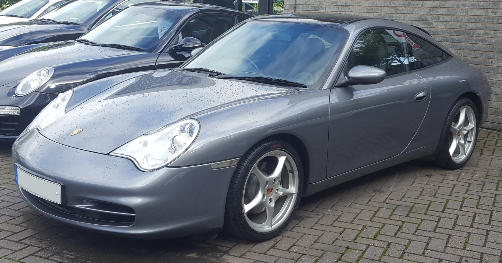 Front side view of a gray sleek sports coupe with distinctive headlights and alloy wheels.