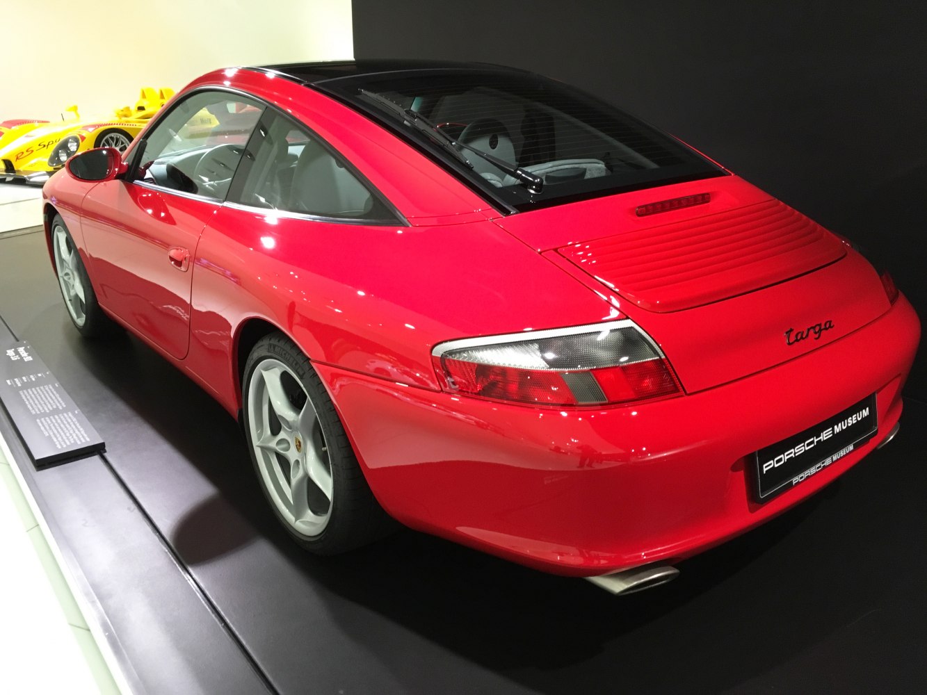Rear side view of red 911 Targa with curved glass roof and sporty design