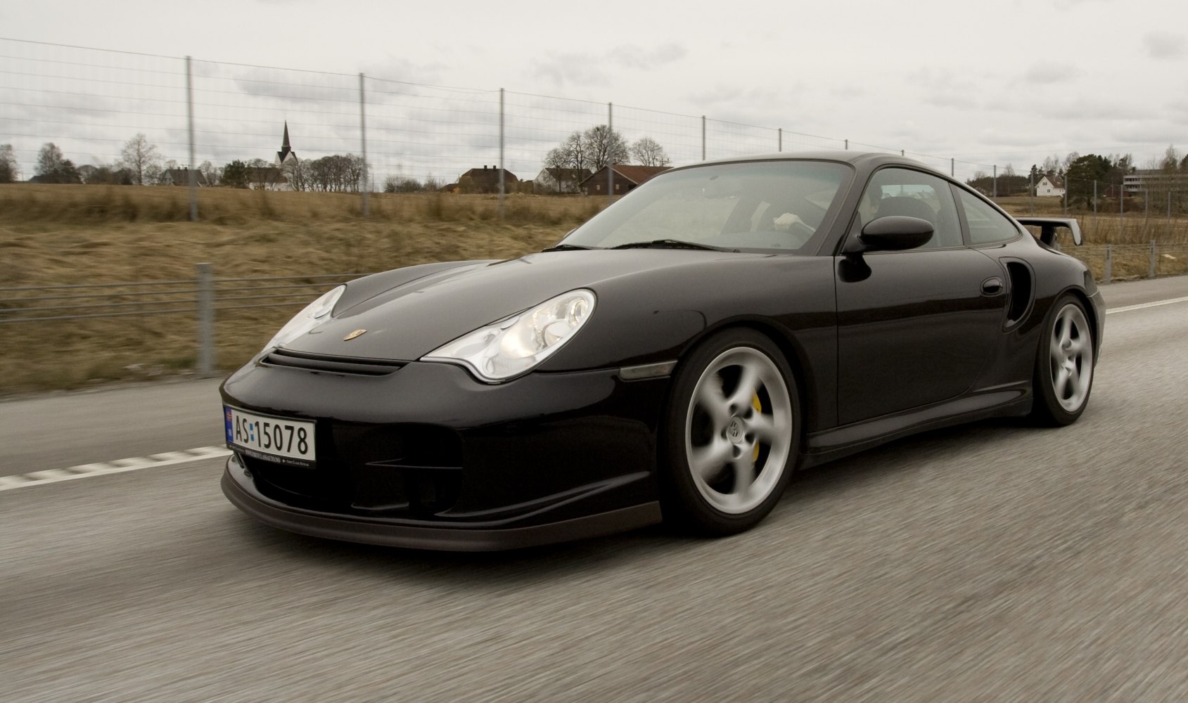Black sports coupe with rounded headlights and prominent rear spoiler.