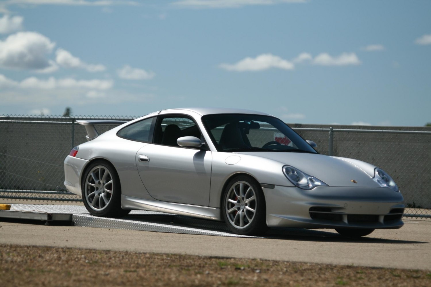 Silver sports coupe with rear wing and alloy wheels