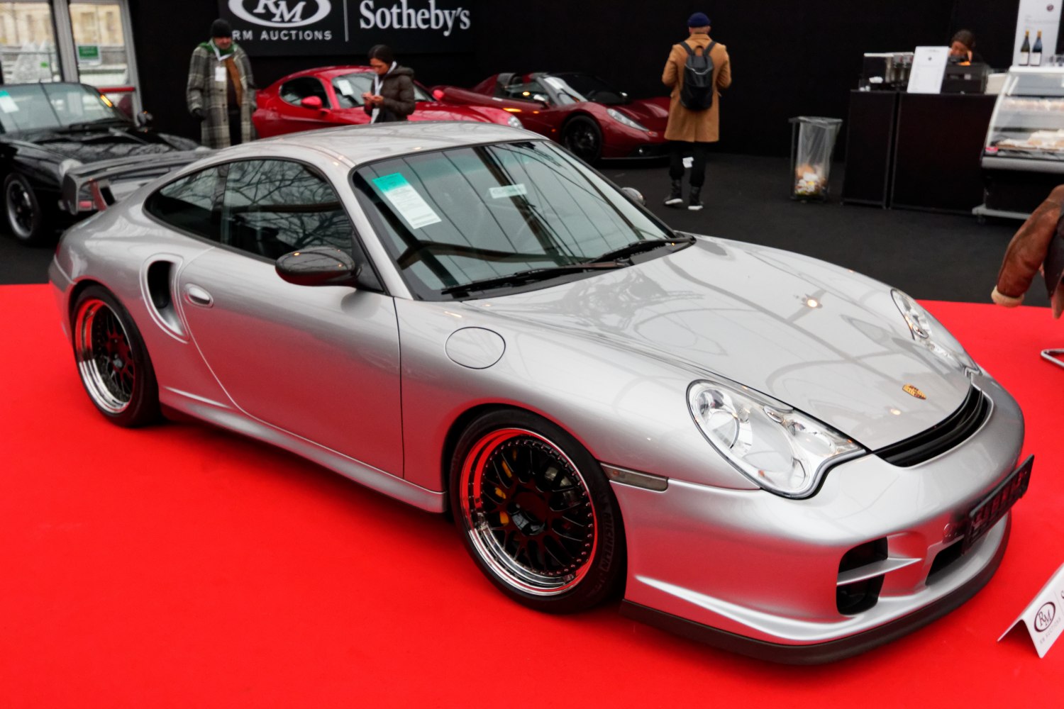 Silver sports coupe with rounded headlights and black multi-spoke rims