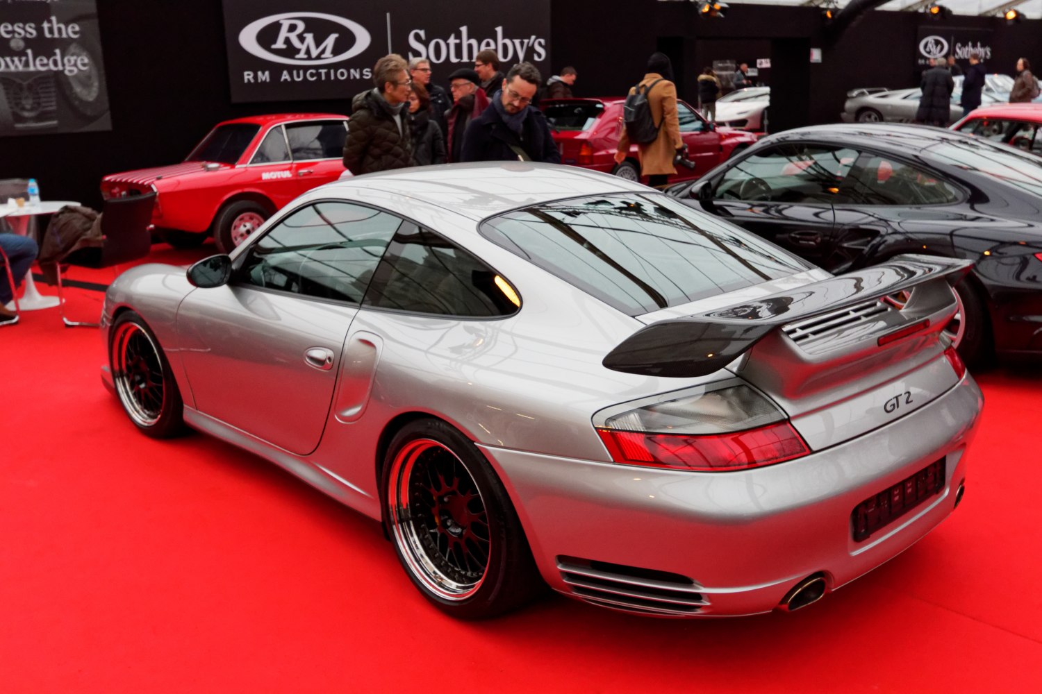 Silver sports coupe with rear spoiler and aggressive rear design.