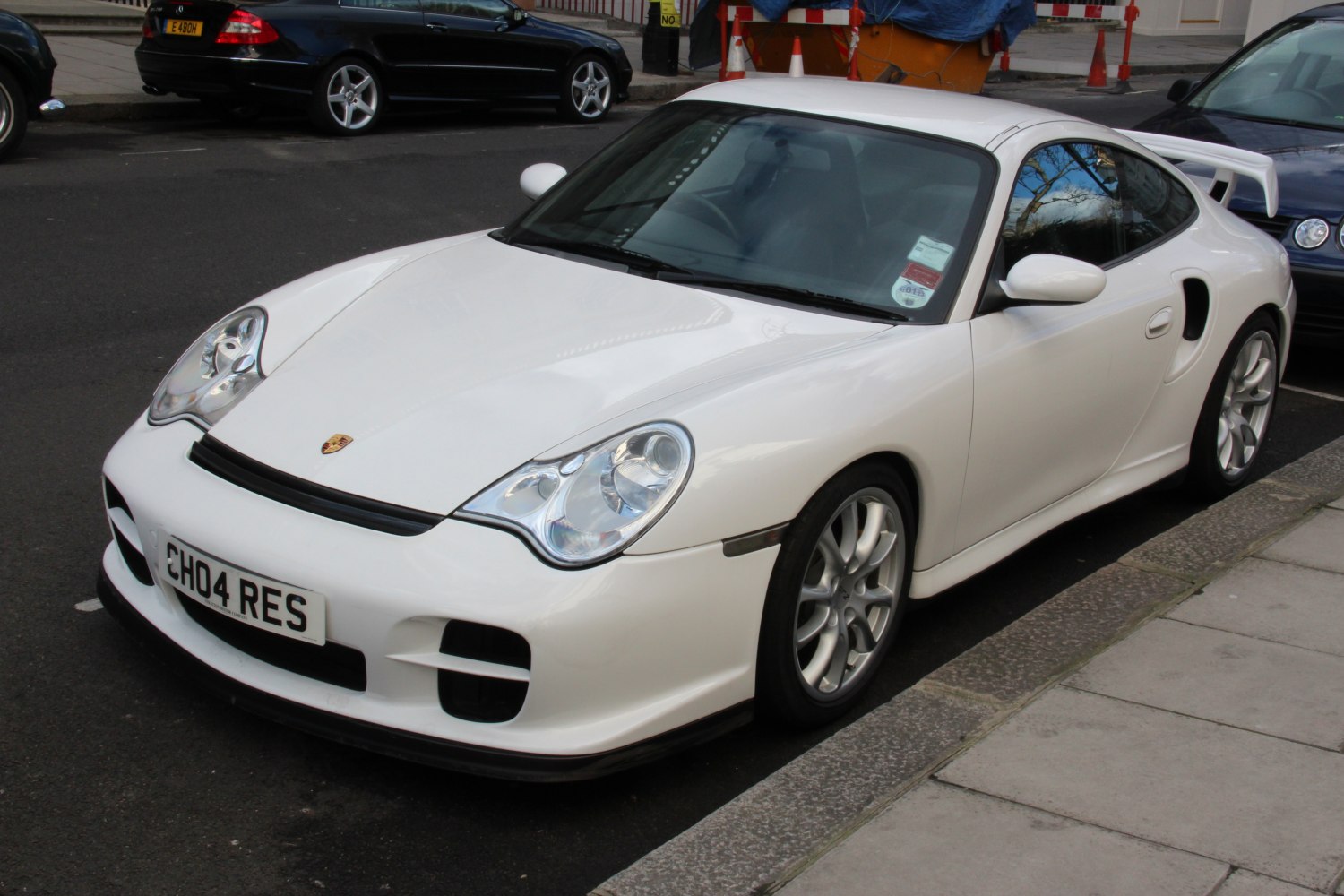 White sports coupe with rear spoiler and alloy wheels